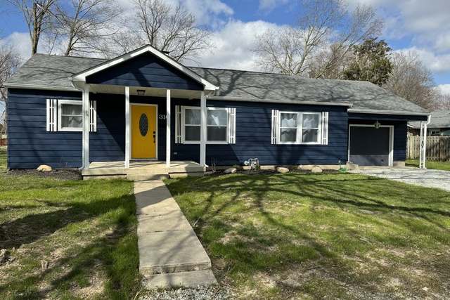 After: the same Pendleton house after a $75K rehab, painted navy with a yellow door